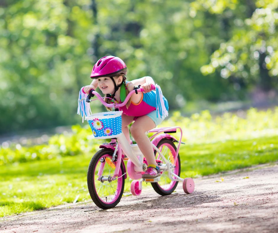 Young girl on bike with training wheels
