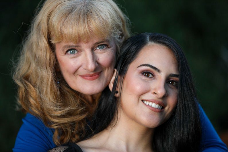 Two women smiling and looking at the viewer