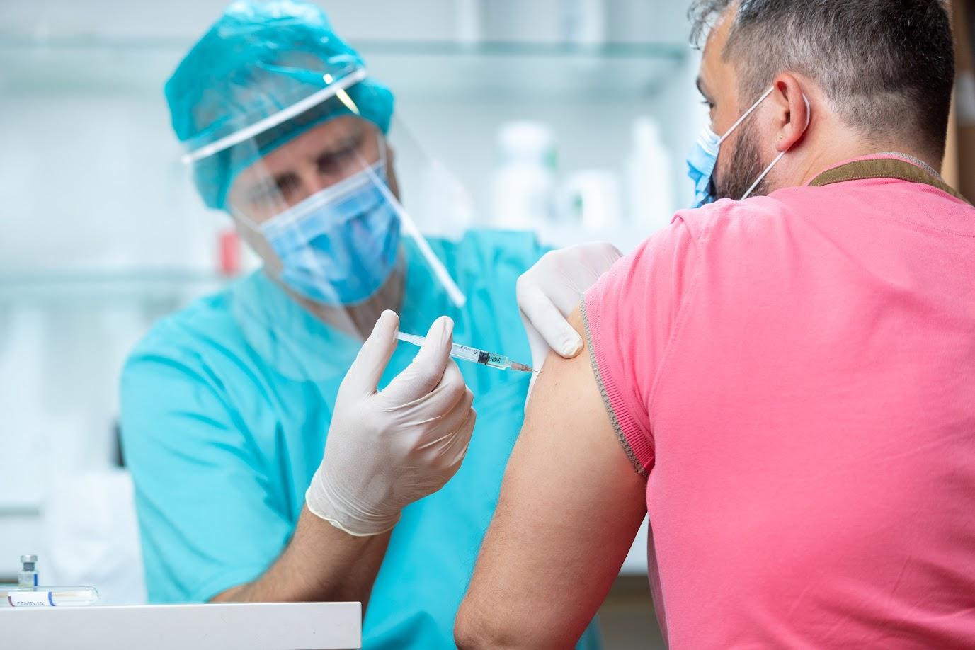 medical professional administering a vaccine to a patient 
