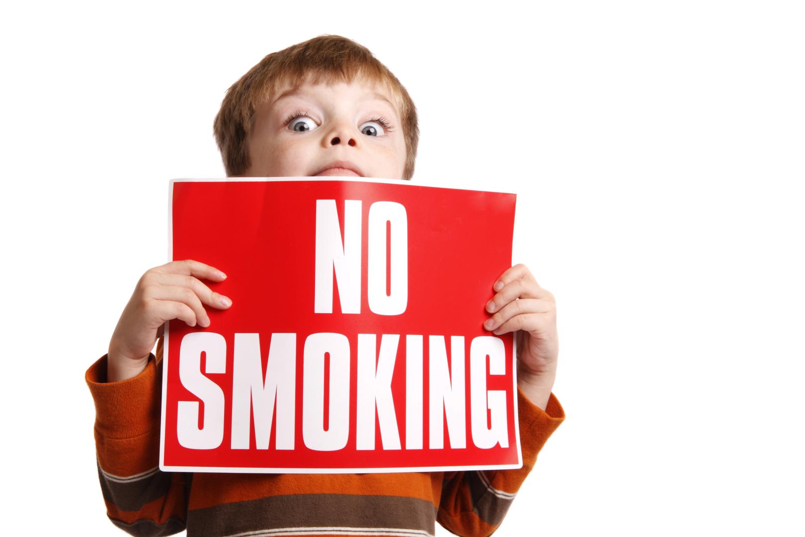 Child holding a No Smoking sign