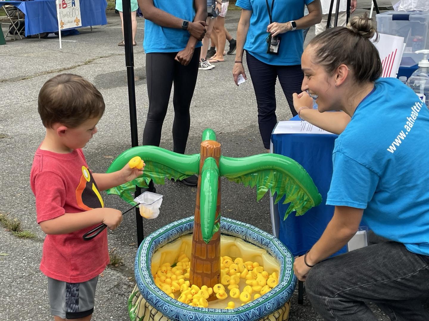 A child playing with rubber ducks at a Department of Health event booth