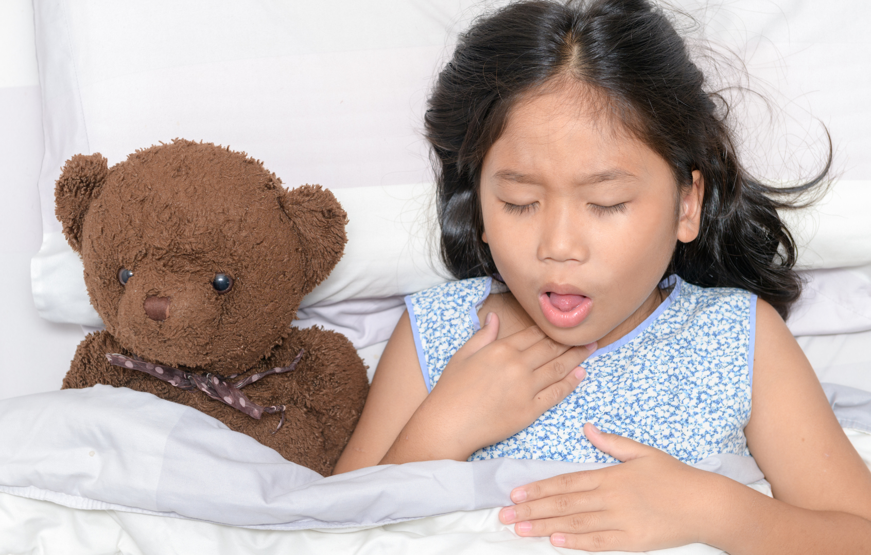 Young child coughing in bed