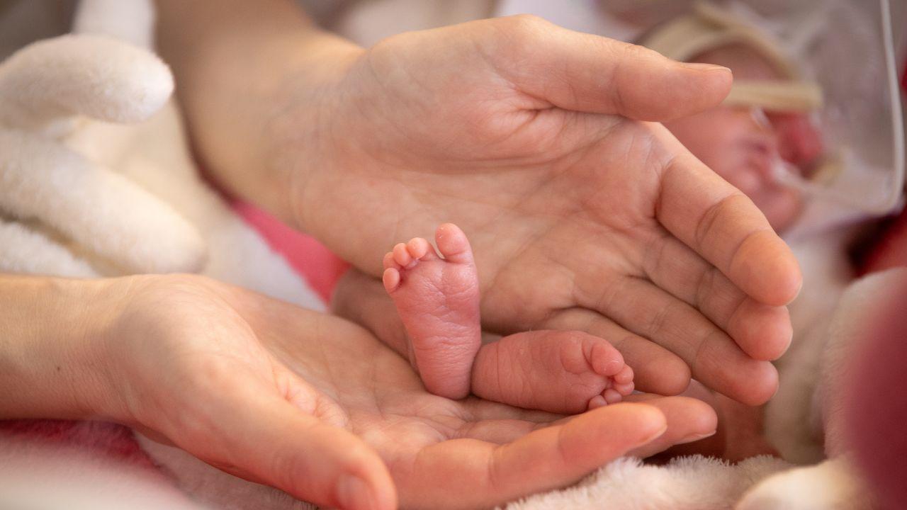 Adult hands holding baby feet